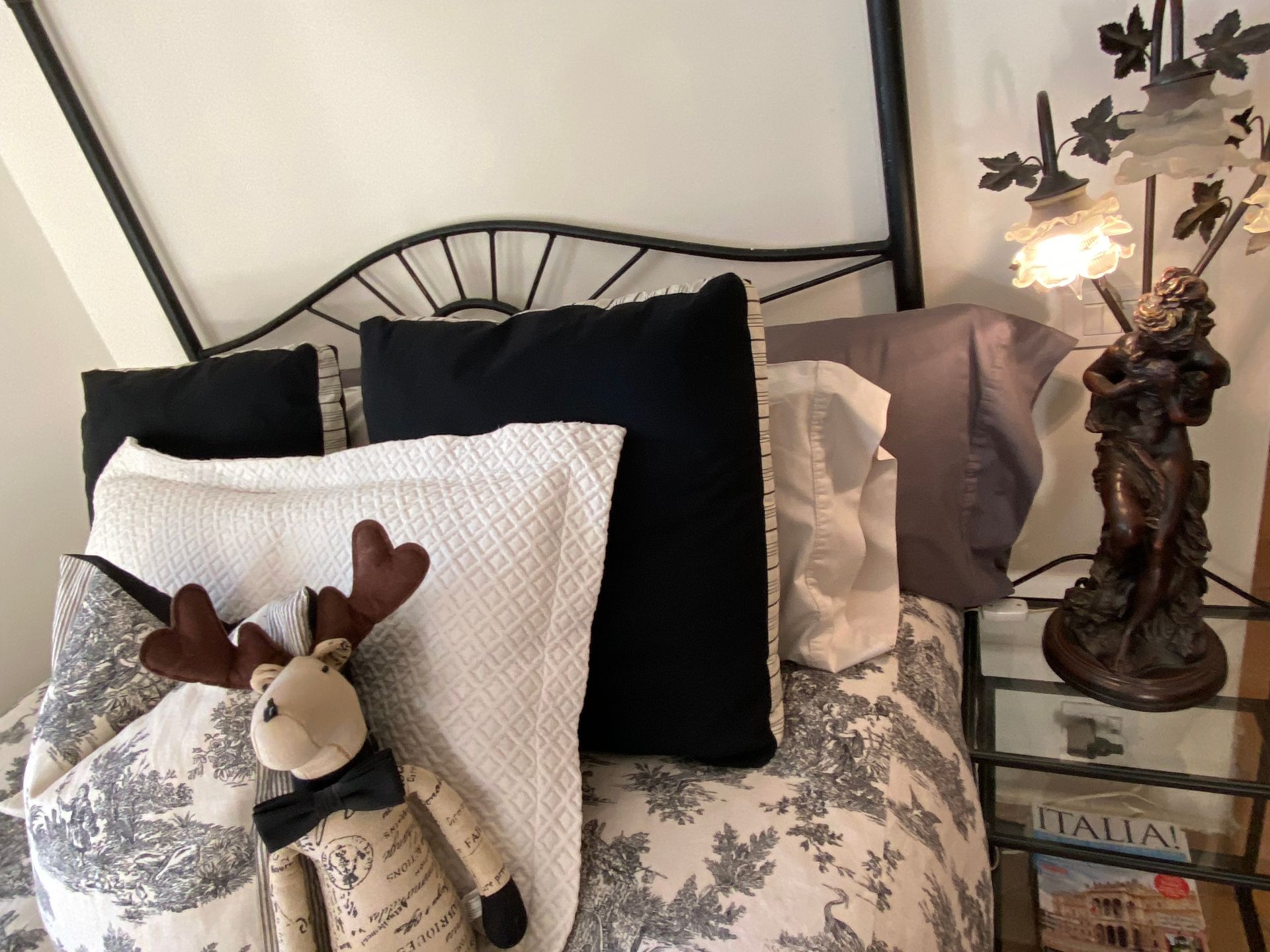 A close-up of a beautiful bed surrounded by antiques in one of our luxury rooms