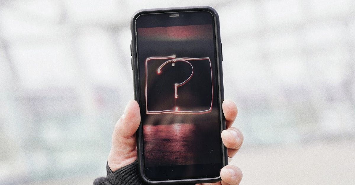 A person is holding a cell phone with a question mark on the screen.
