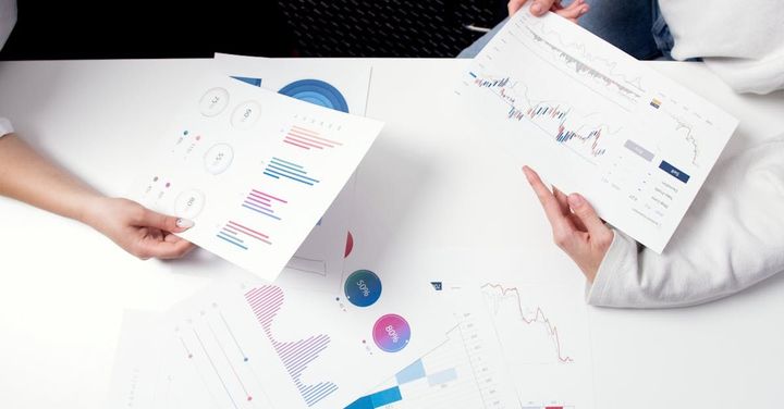 Two people are sitting at a table looking at graphs.