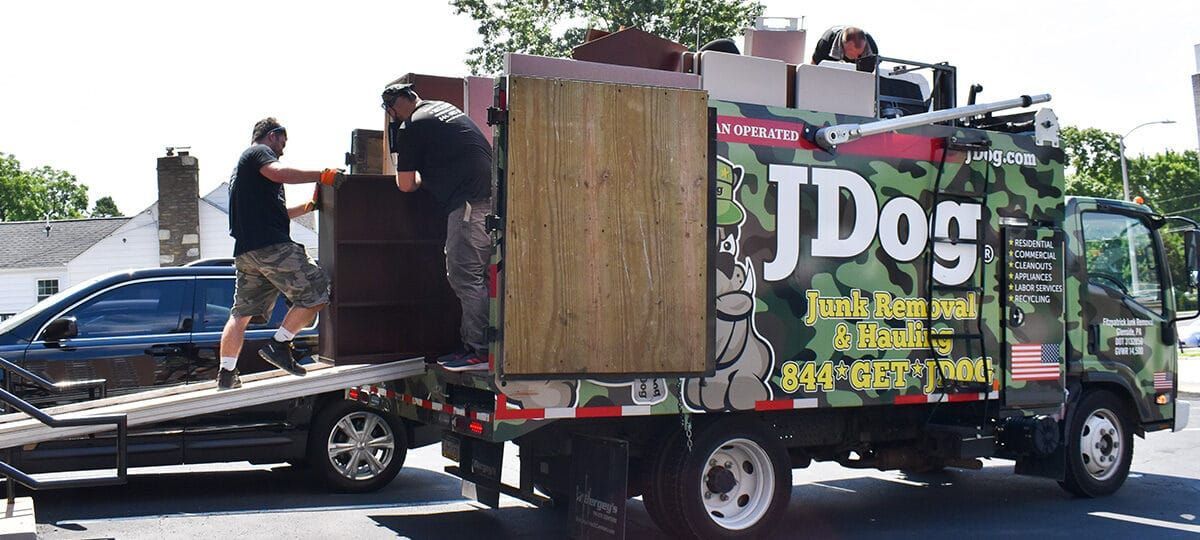 Two men loading furniture onto a moving truck with camouflage design.