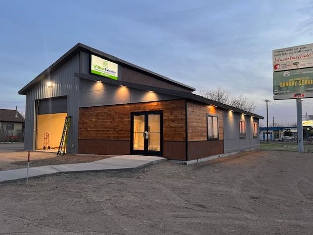 Building exterior with wood and gray siding, sign 