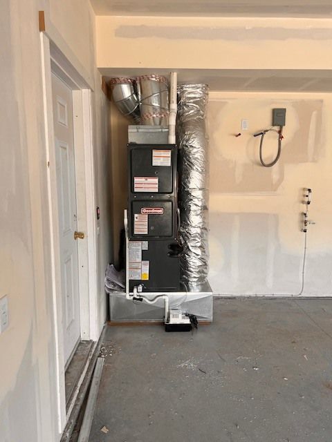 Furnace and ductwork in a garage; silver and gray components.