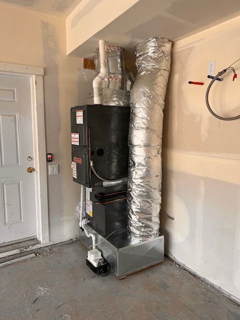 HVAC system installed in a garage; includes furnace, ductwork, and condensate pump.