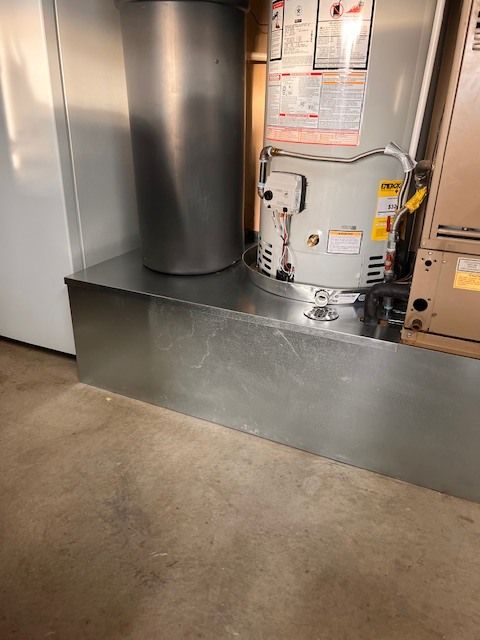 Furnace unit in a basement setting with a metal flue.