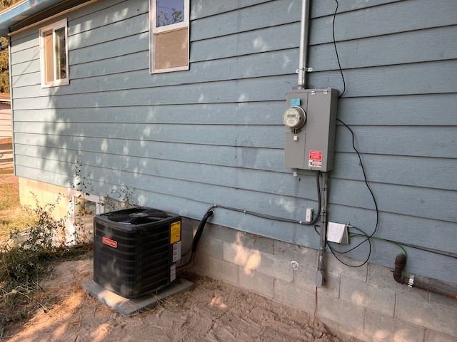 Blue house exterior with electrical meter, AC unit, and conduit.