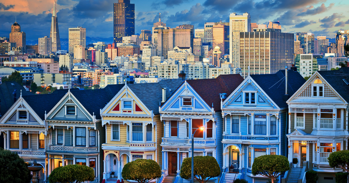 A row of houses with a city skyline in the background A row of houses with a city skyline in the background