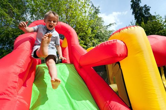 a young boy is playing on an inflatable slide