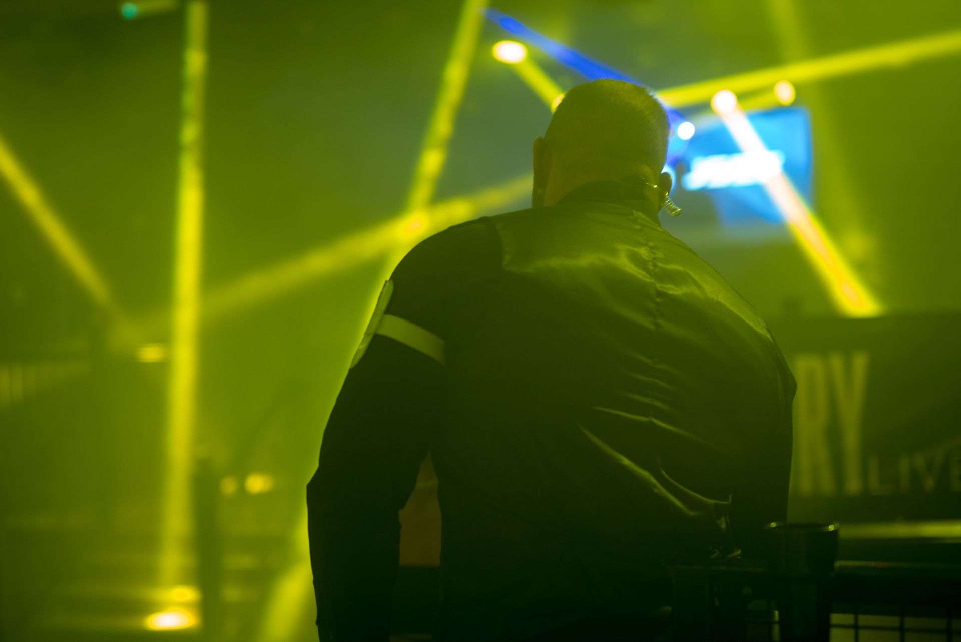 A Security Guard Watching a Stage Lit With Yellow Lights — Clinton Security Services In Gold Coast, QLD