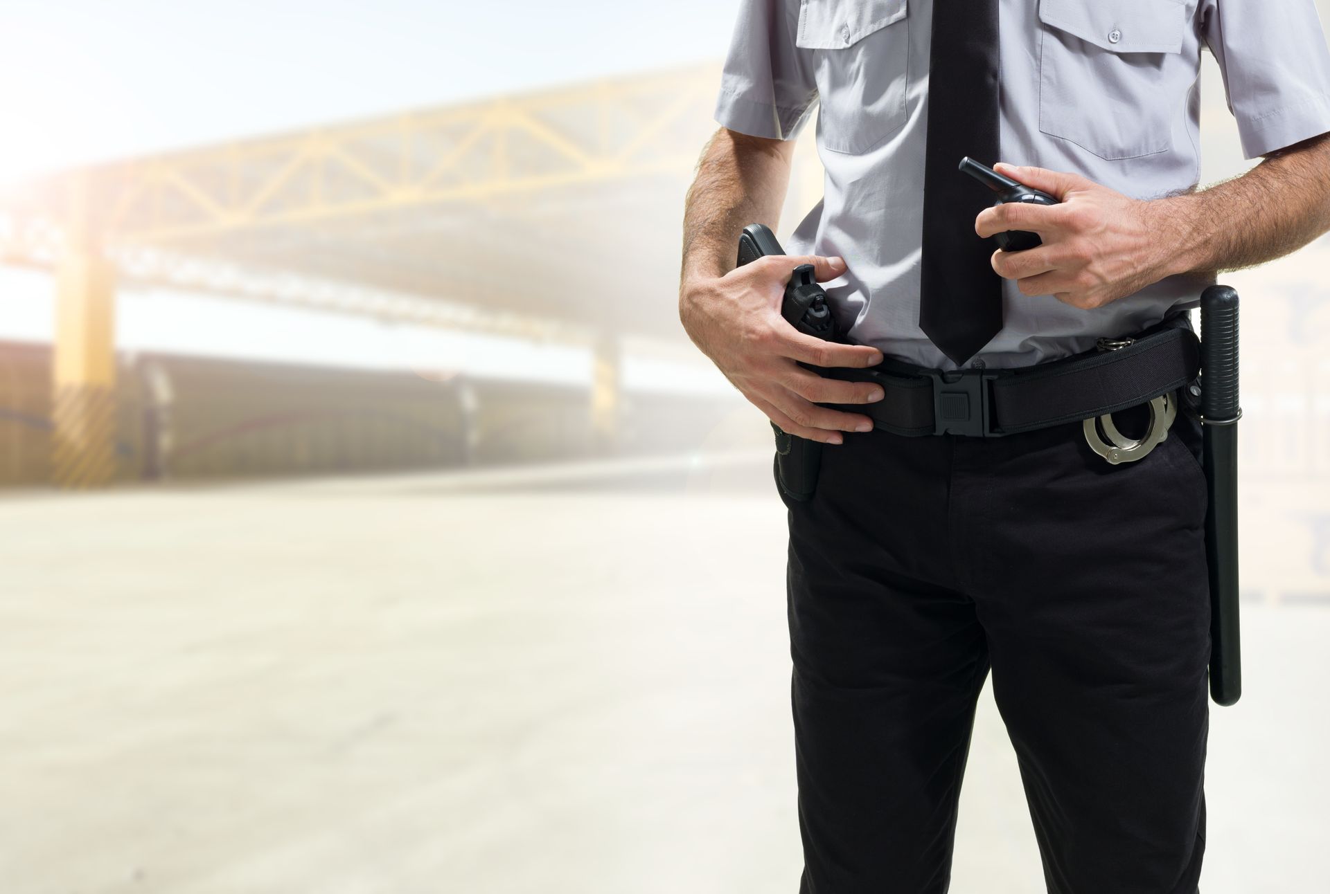 A Security Guard in Uniform, Holding a Radio and Standing — Clinton Security Services In Mudgee, NSW
