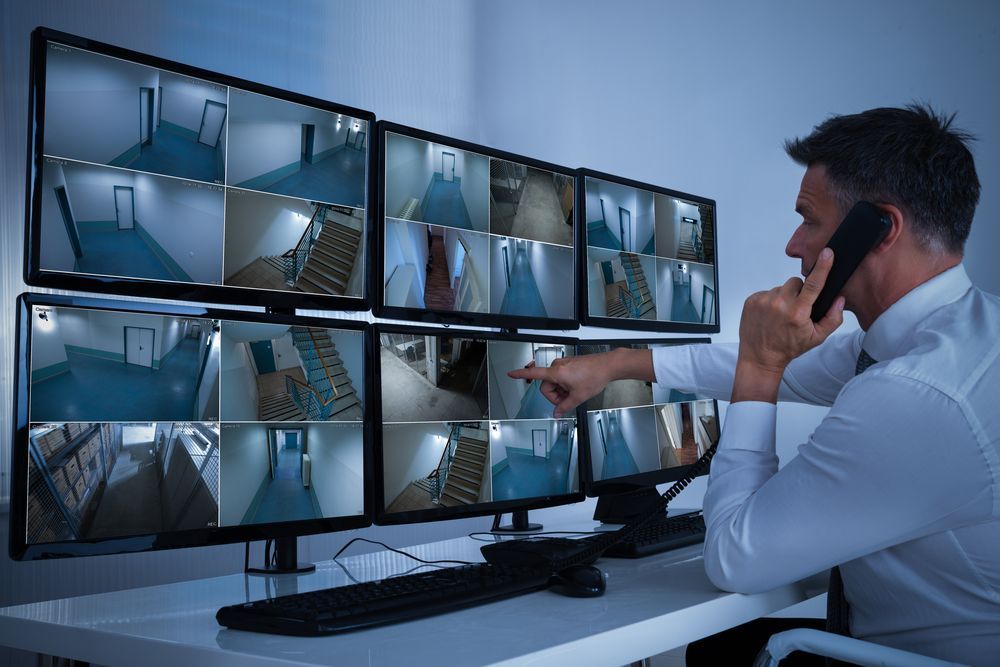 A Man in a Security Room Monitoring Cameras — Clinton Security Services In Gold Coast, QLD