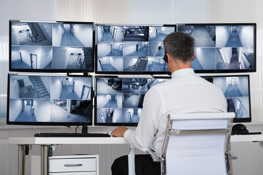 Man Monitoring Security Cameras in an Office — Clinton Security Services In Armidale, NSW