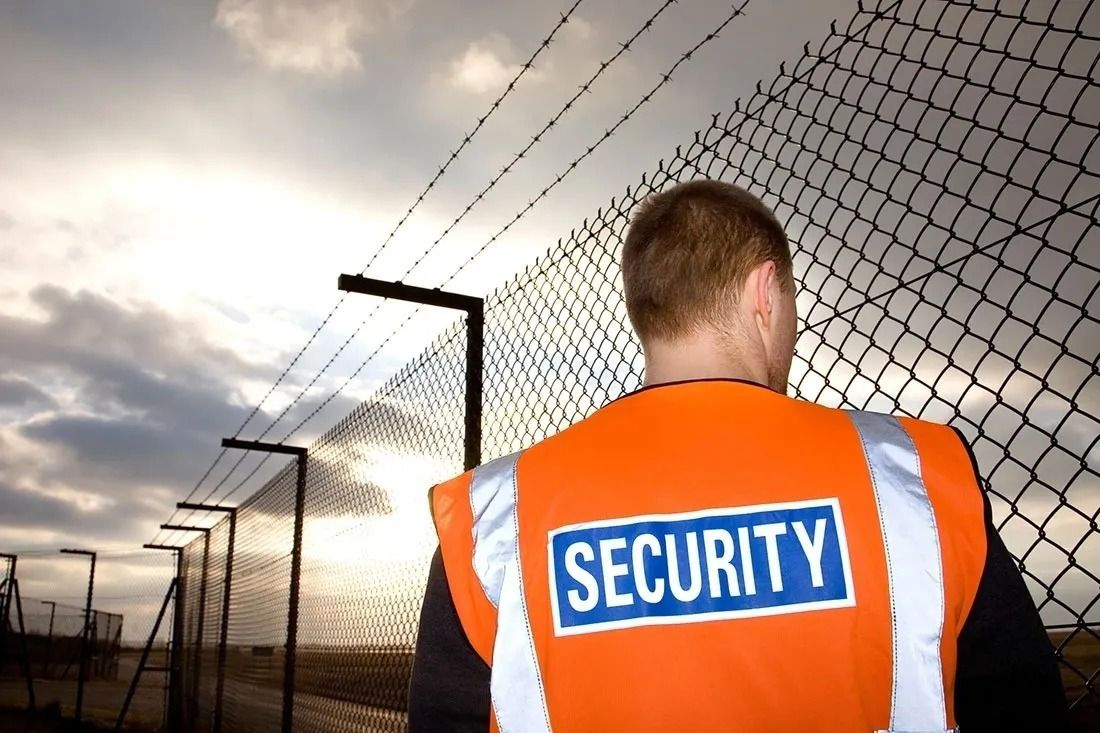 Security Guard Stands by a Fence — Clinton Security Services In Armidale, NSW