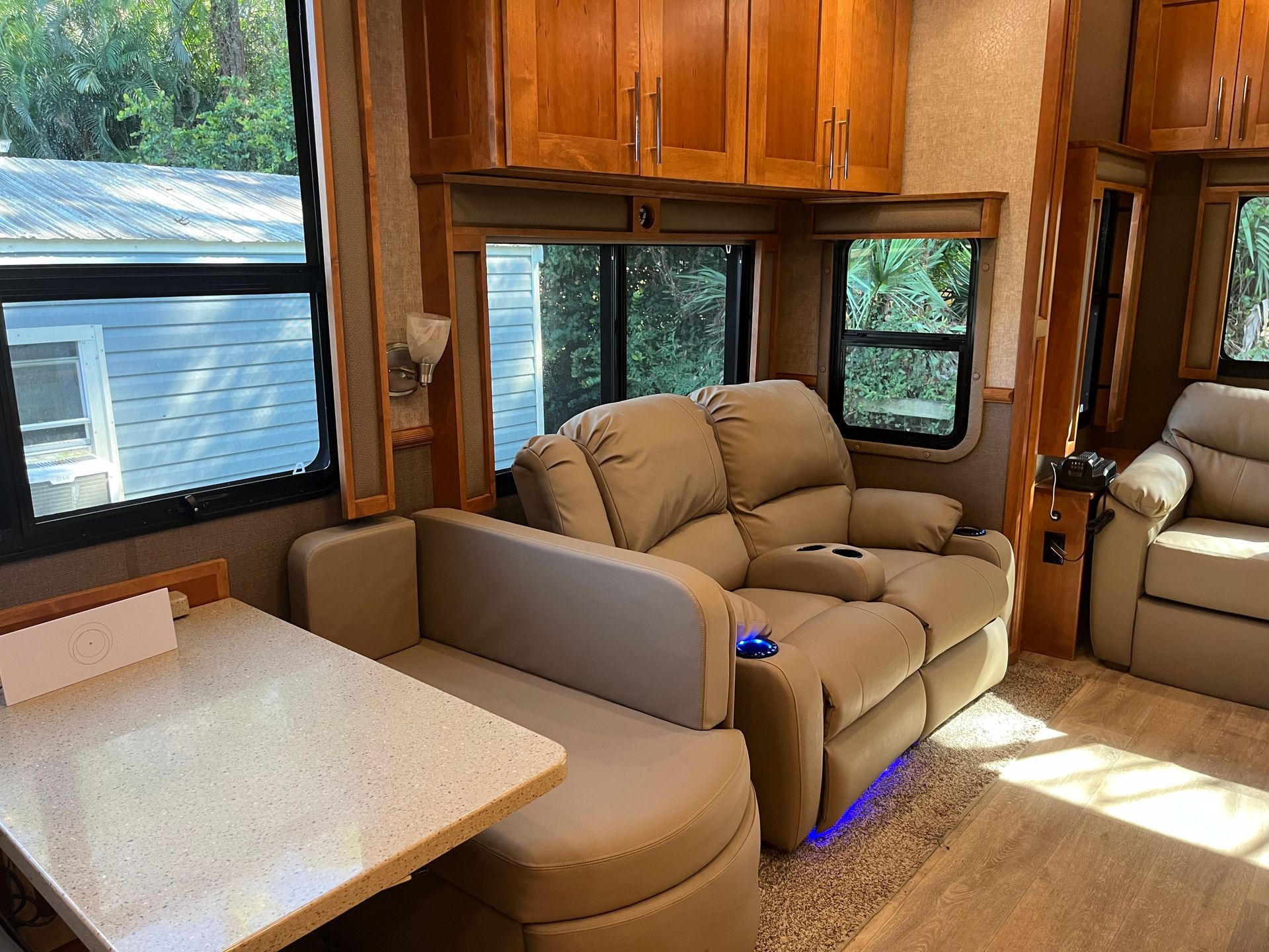 A living room in a rv with a couch , chair and table.