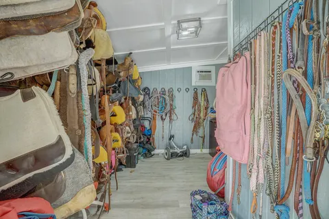 A room filled with lots of saddle pads and bridles.
