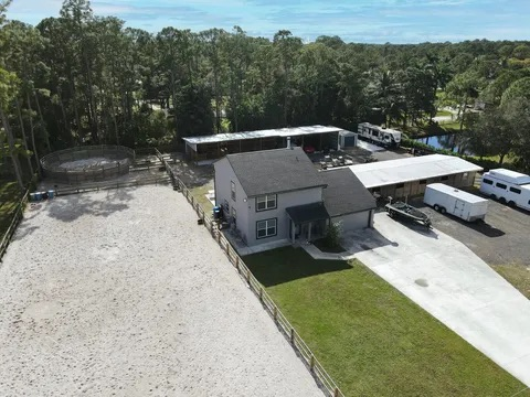 An aerial view of a house with a lot of cars parked in front of it.