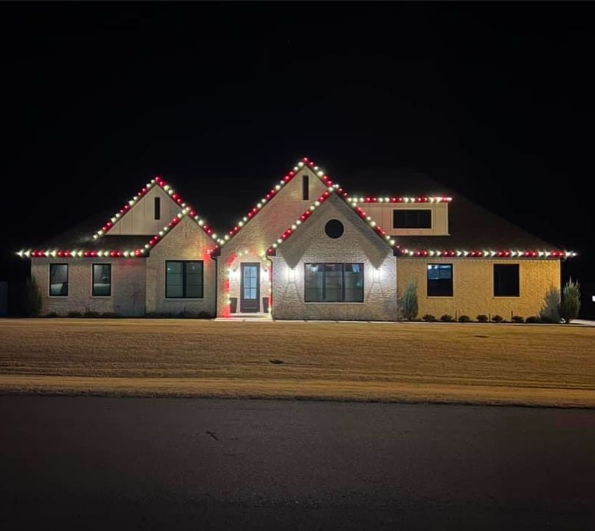 Brick patterned, dark gray concrete walkway curving through a green lawn.