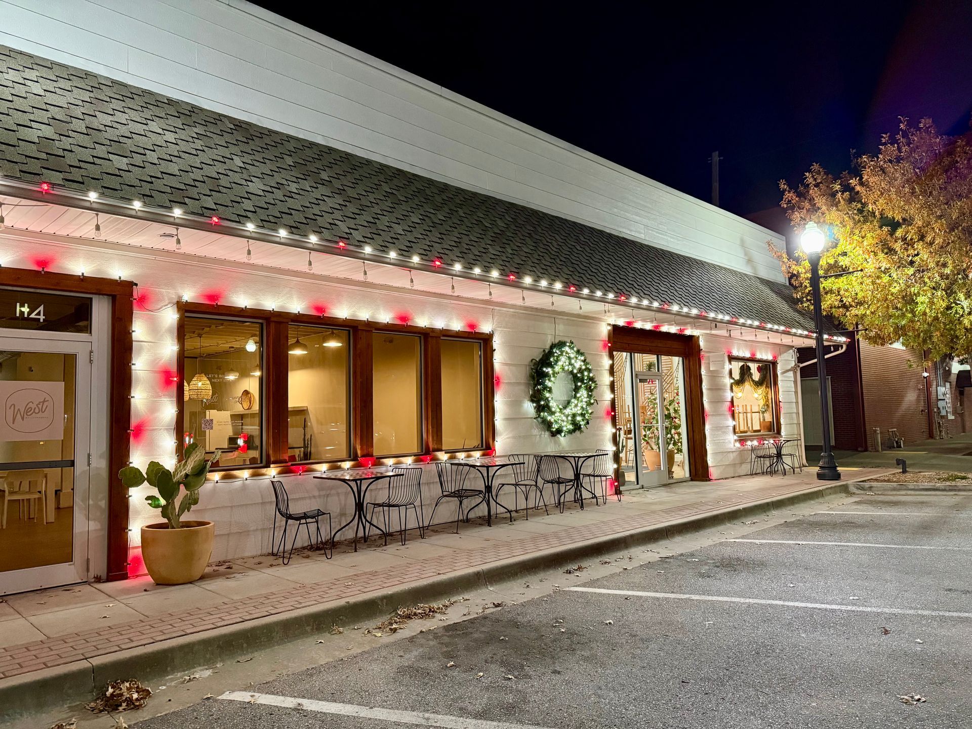 Concrete sidewalk with dark stain, next to brick pavers and dry grass.