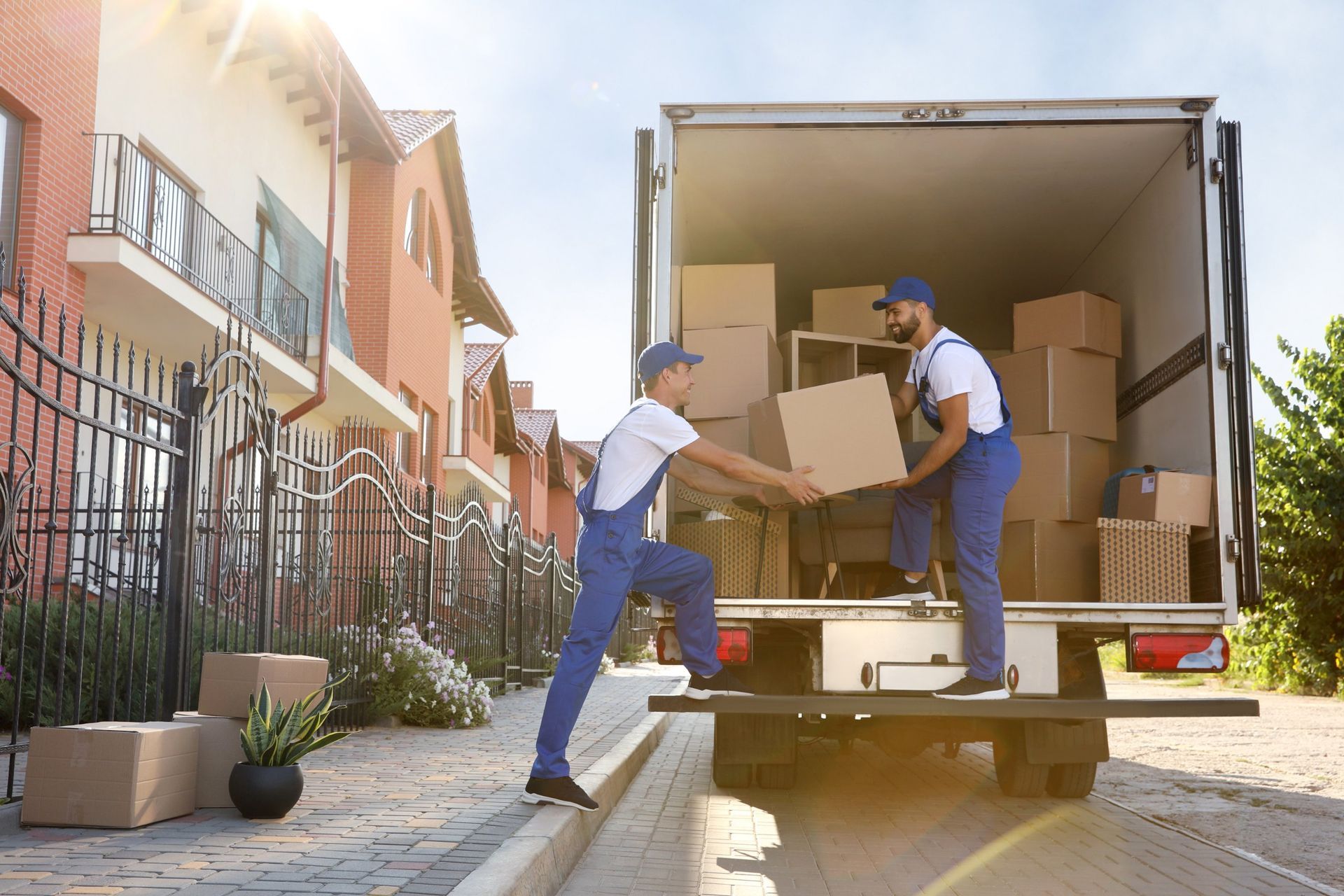 Two men are loading boxes into a moving truck.