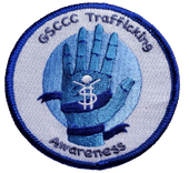 A circular patch with blue, white, and light blue colors showing a hand with a human-shaped symbol for trafficking awareness.