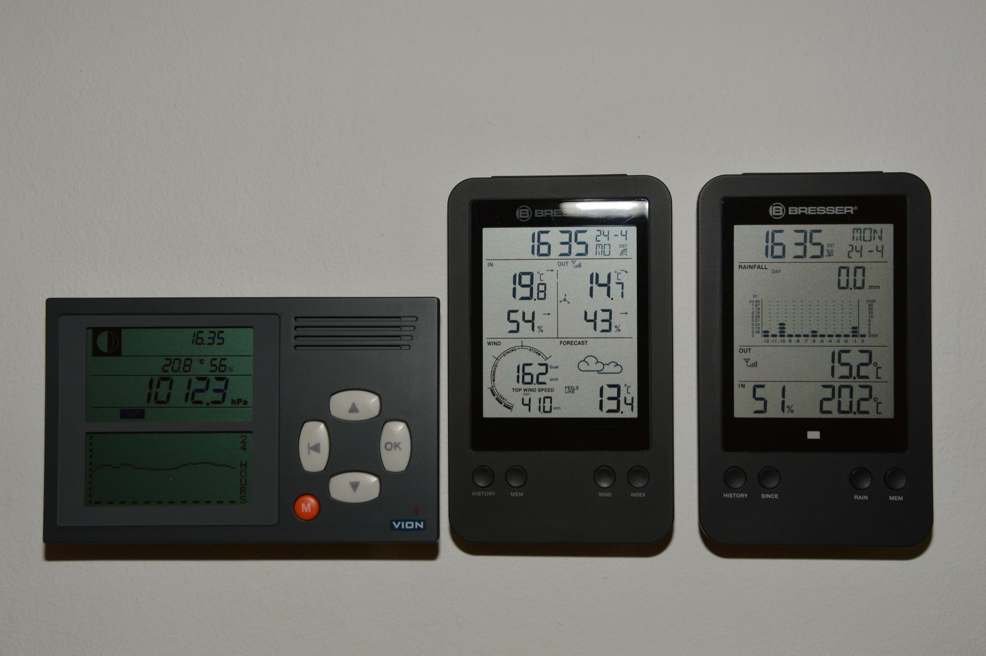 Three black digital weather stations displaying data on a white background.