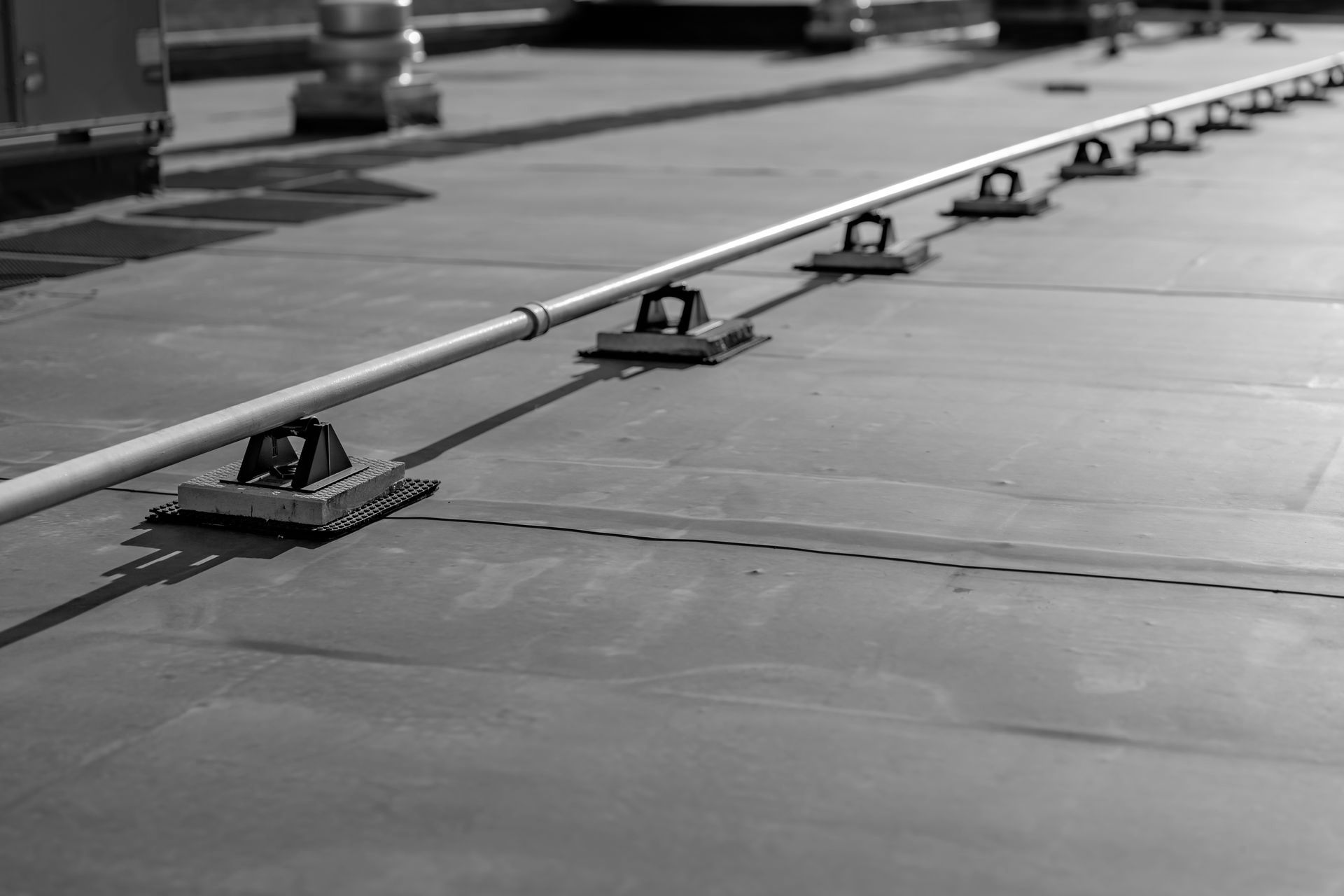 Une photo en noir et blanc d'un toit auquel est attachée une ligne de sécurité.