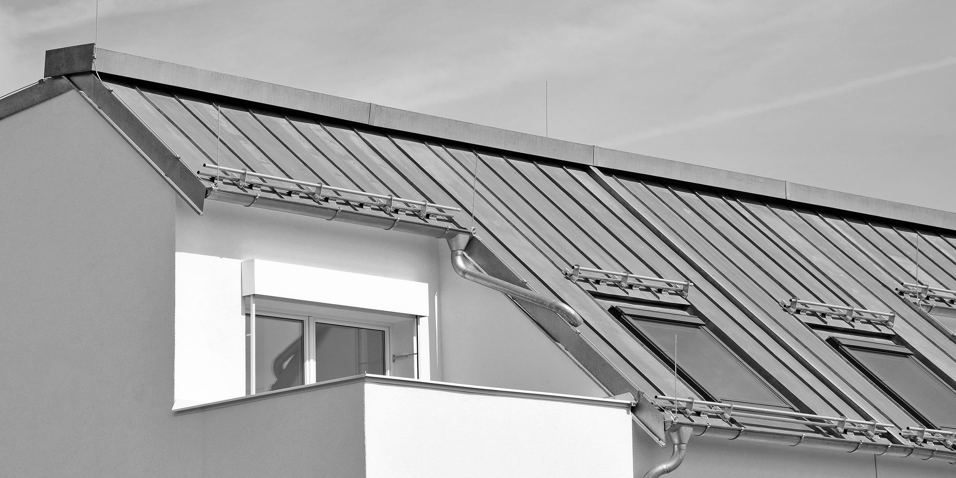 Une photo en noir et blanc d'une maison avec un toit en métal.