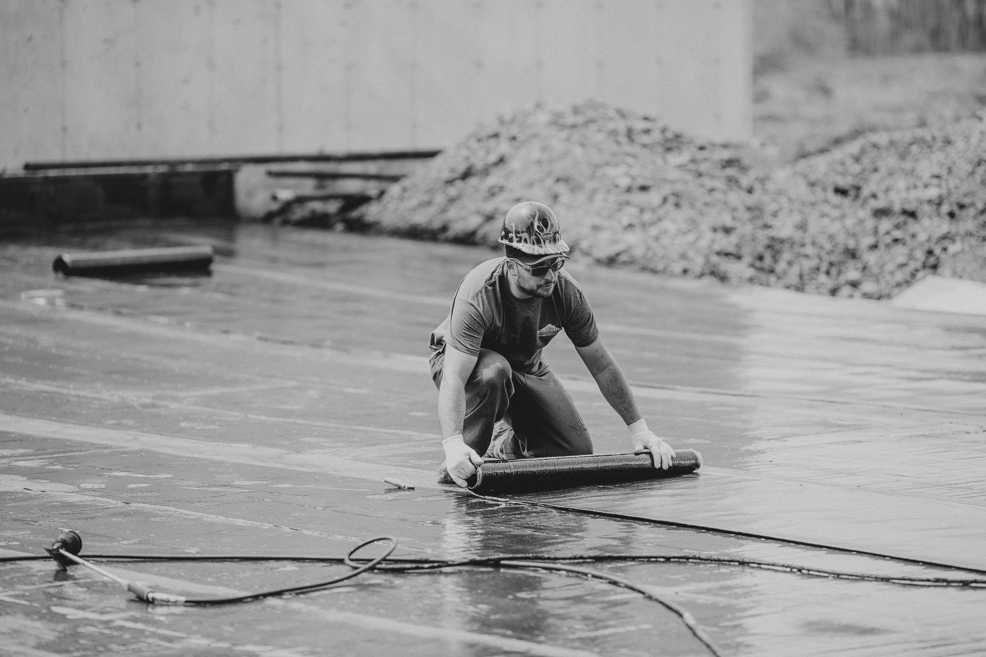 Une photo en noir et blanc d'un homme agenouillé sous la pluie.