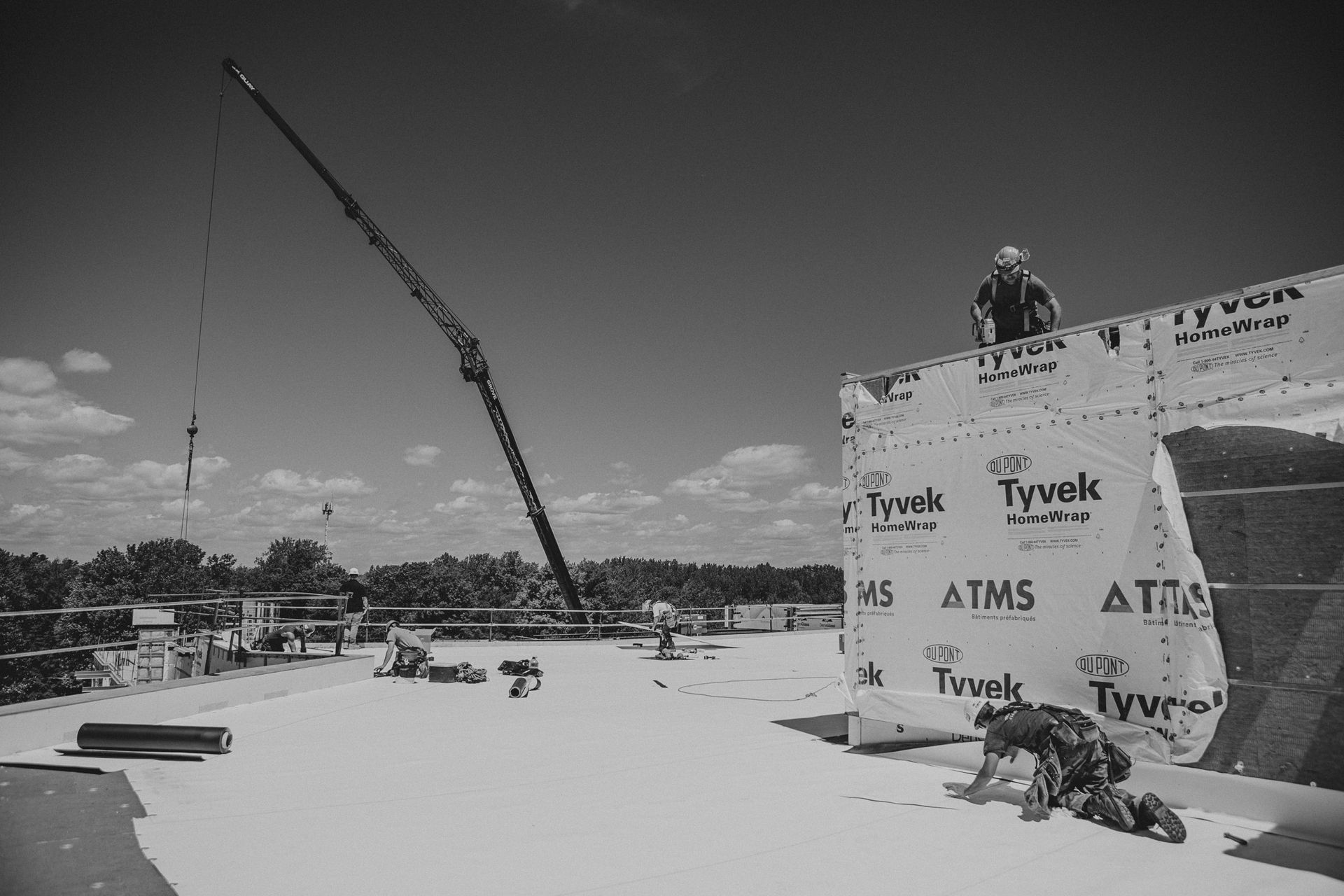 Une photo en noir et blanc d'un chantier de construction avec une grue en arrière-plan.