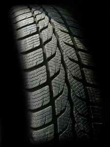 A close up of a tire on a black background