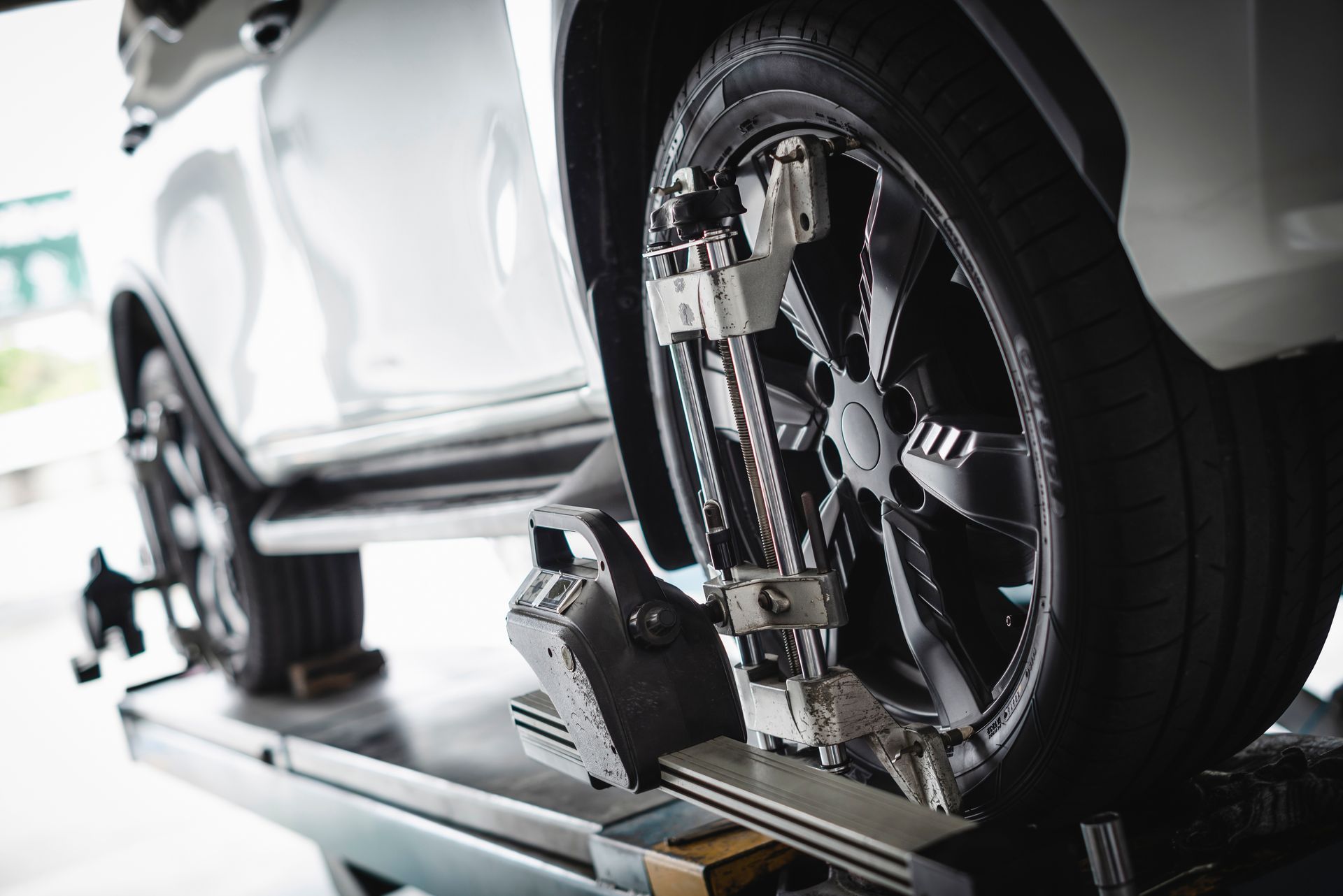 A car is being aligned with a machine in a garage.