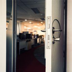 A locksmith opening an office door. A locksmith opening an office door.