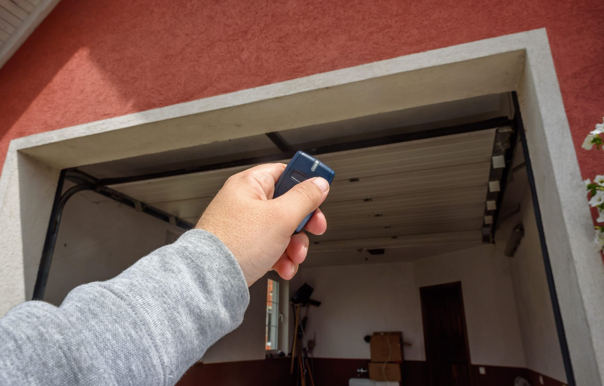 Person using garage door, highlighting replacement garage remotes operation. Person using garage door, highlighting replacement garage remotes operation.