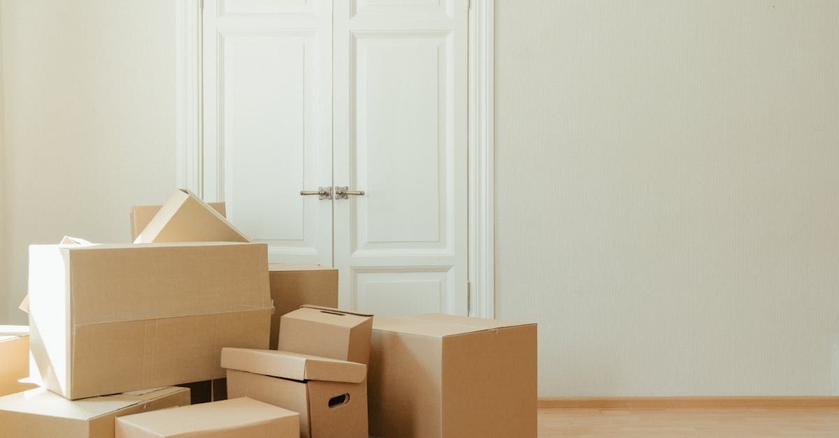 A bunch of cardboard boxes are stacked on top of each other in an empty room.