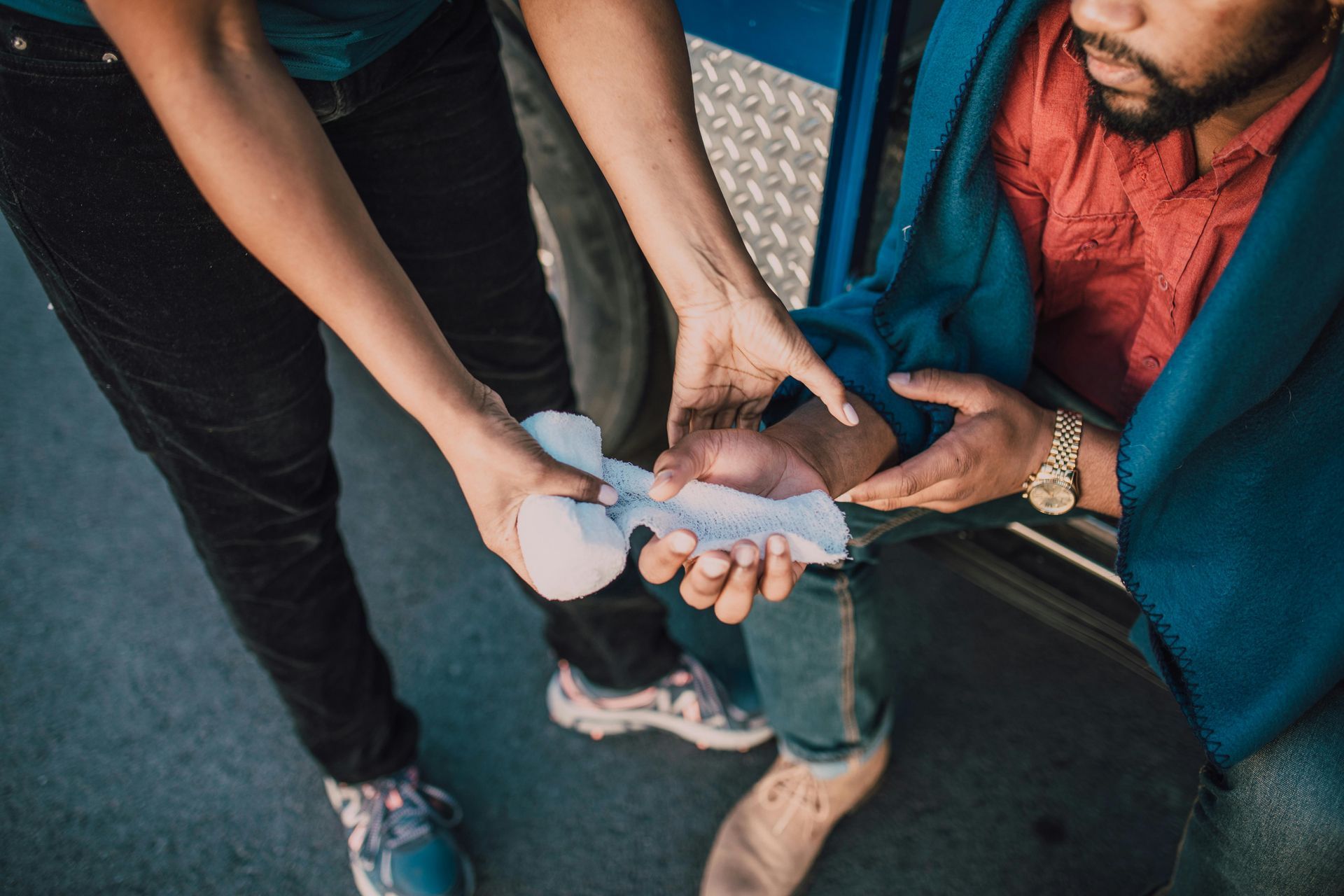 A woman is helping a man with a bandage on his leg.