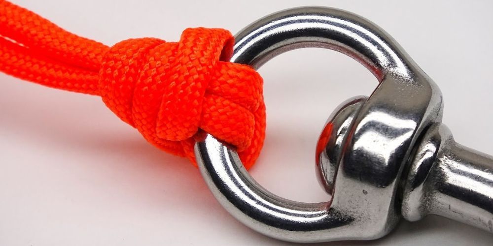 A close up of a metal hook with a red rope attached to it.