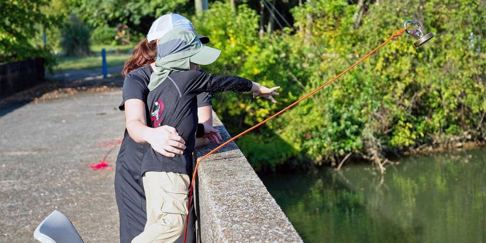 A woman and a child are fishing on a bridge.