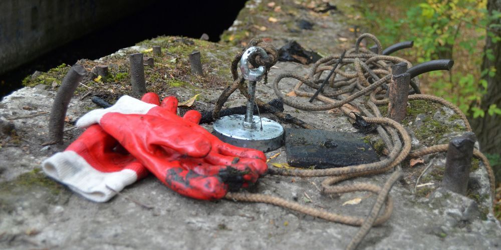 A pair of red and white gloves are laying on a concrete surface.