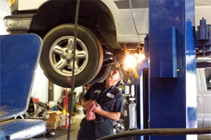 Mechanic Checking Car Axle — Hendersonville, NC — Coggins Transmissions/Fieler Automotive Inc.