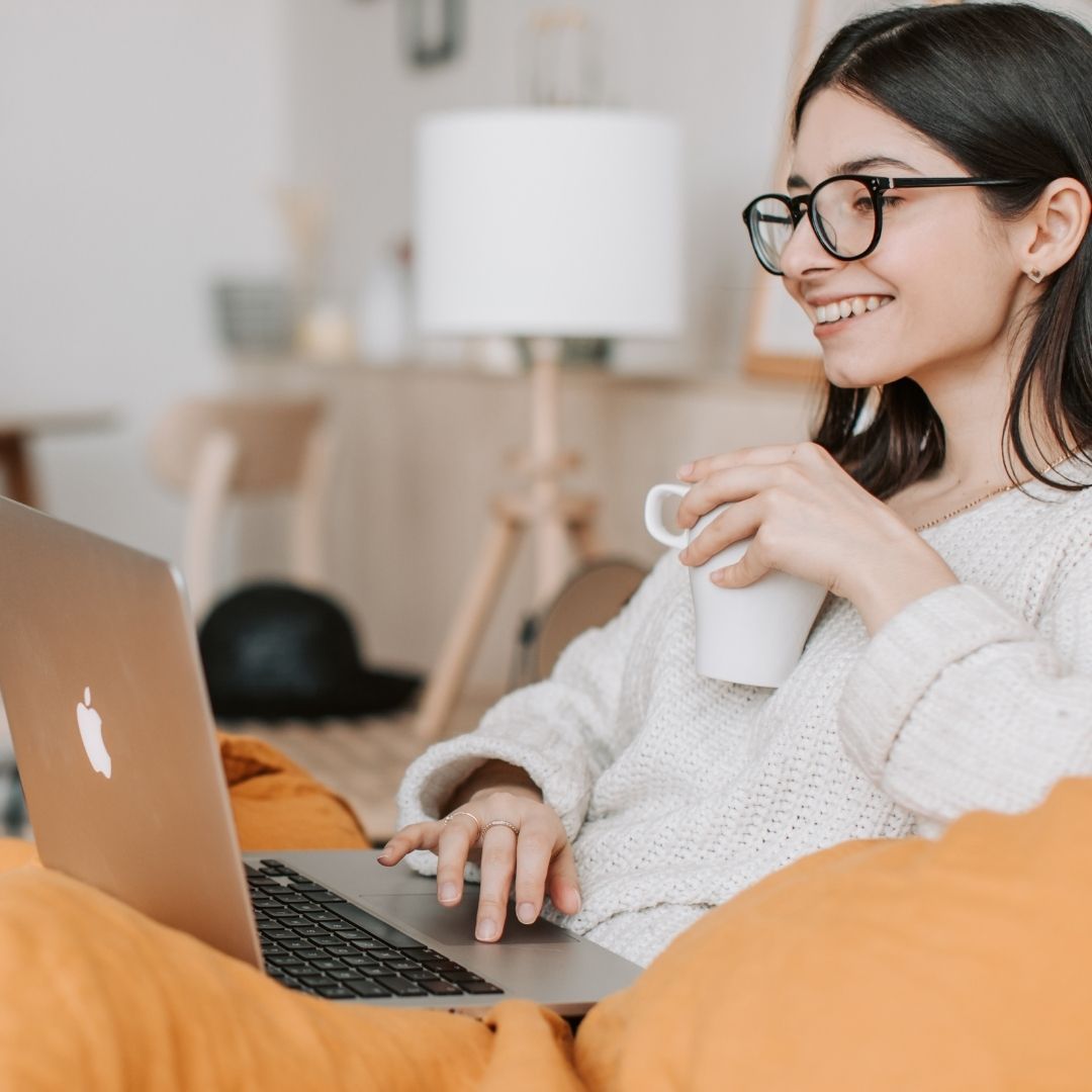 a woman smiling while on her laptop