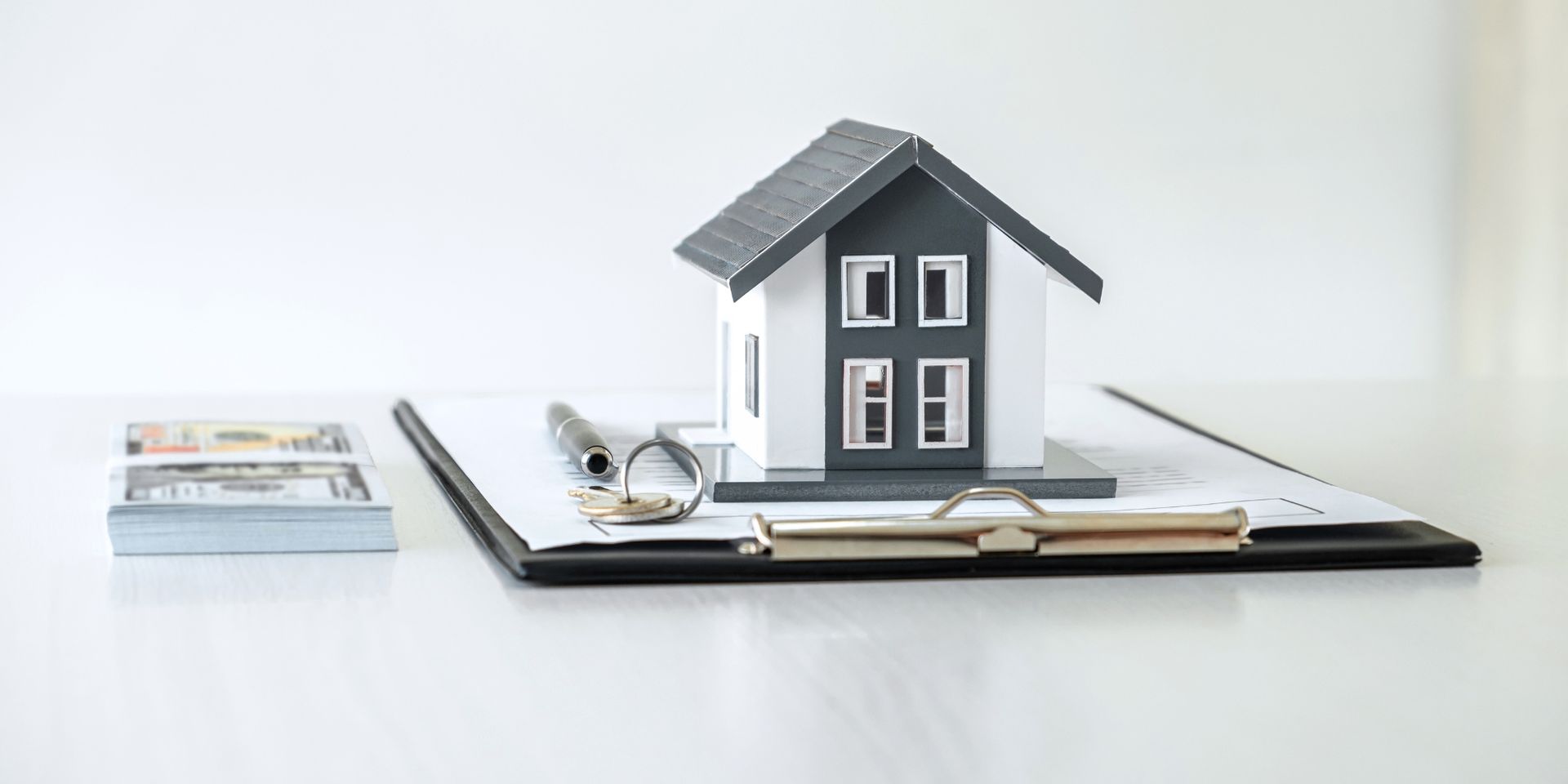 Model home and keys on top of a clipboard