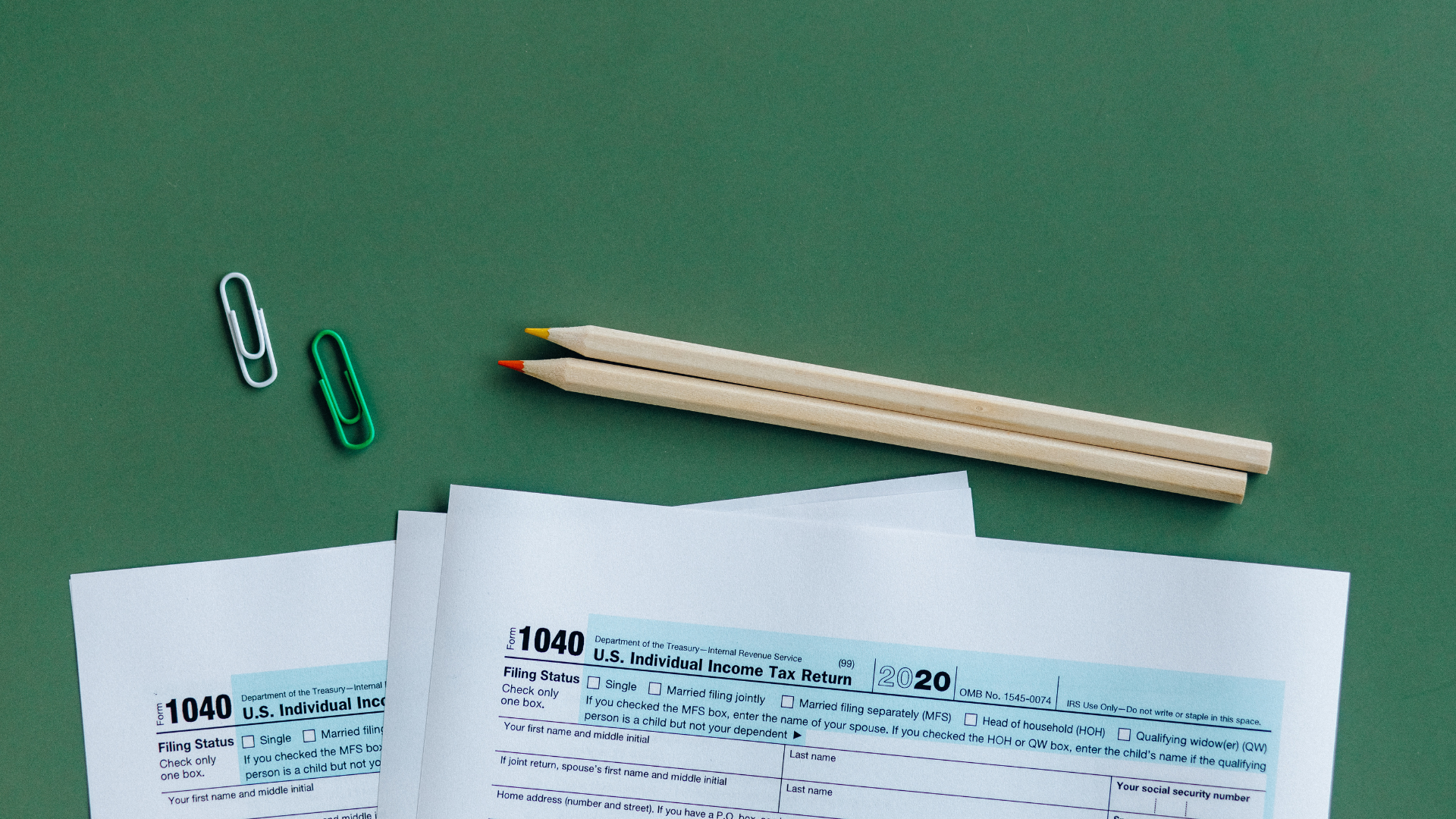 A calculator is sitting on a table next to a notebook and pencils.