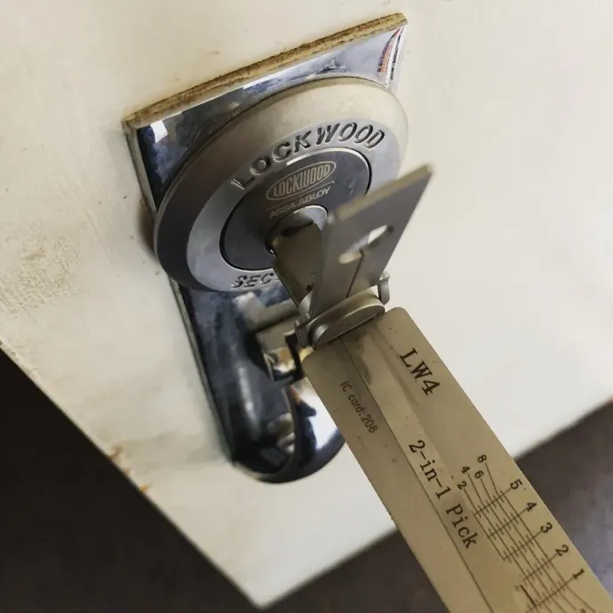 Lockwood door lock being picked open with a specialized key pick tool.
