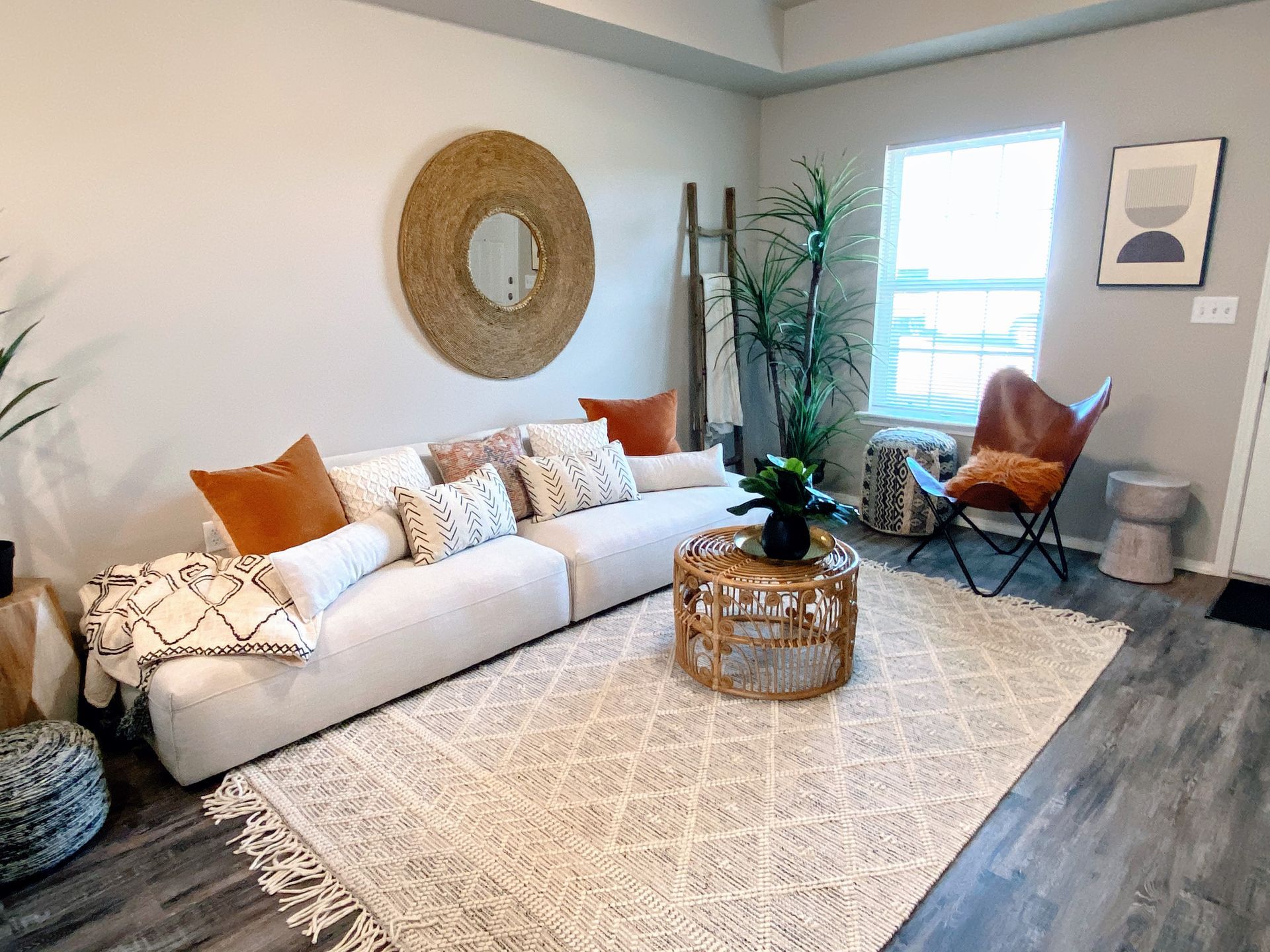 Living room with a white couch, rug, and bohemian decor.
