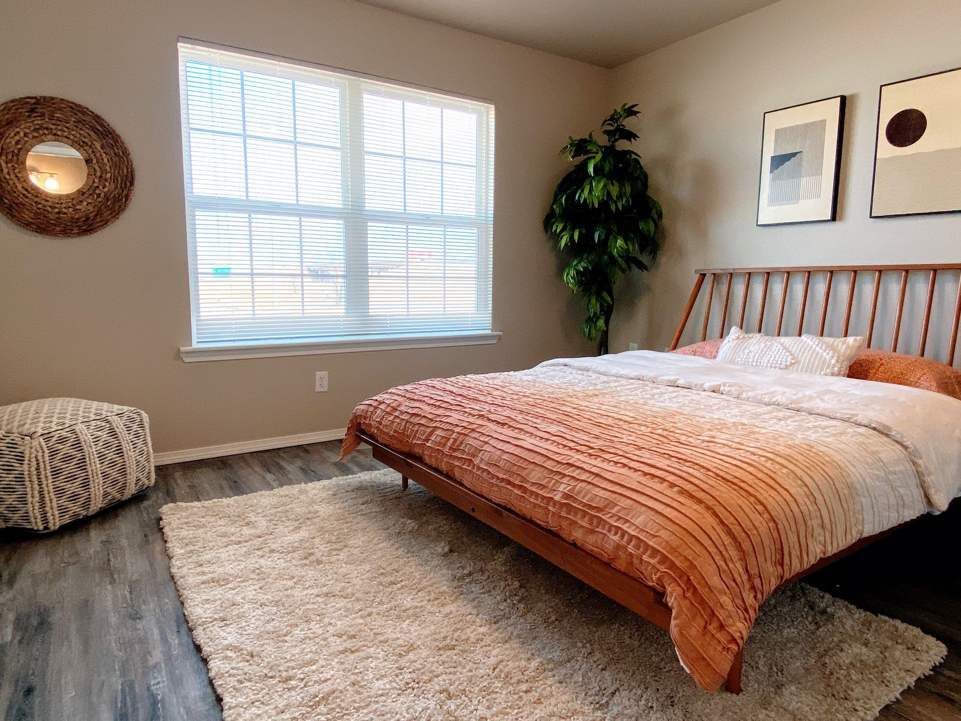 Bedroom with bed, rug, and decorative items. Earth tones dominate.