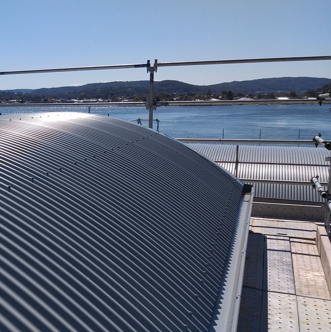 A house with a red roof and a white gutter — Glenroofing Pty Ltd In Taree, NSW