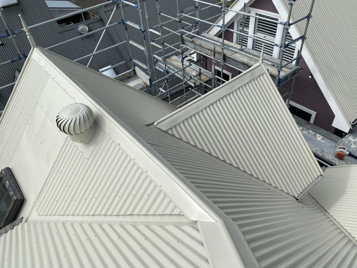 A White Roof With Scaffolding On The Side Of It — Glenroofing Pty Ltd In Gloucester, NSW
