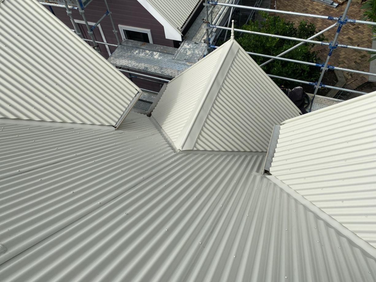 A White Corrugated Metal Roof Is Being Installed On A House — Glenroofing Pty Ltd In Forster, NSW