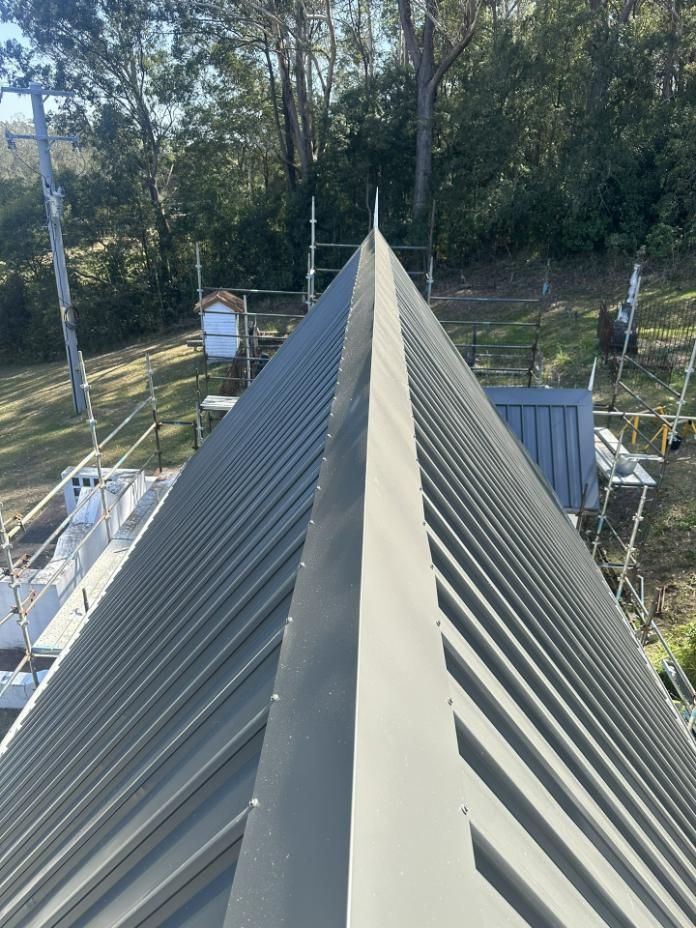 The Roof Of A House Is Being Built With Scaffolding And Trees In The Background — Glenroofing Pty Ltd In Taree, NSW