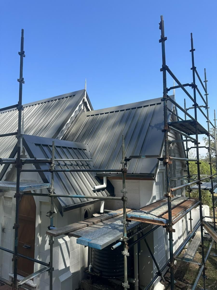 A House With A Metal Roof And Scaffolding Around It — Glenroofing Pty Ltd In Newcastle, NSW