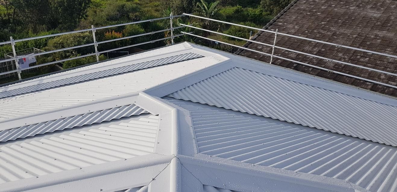 A White Roof With A Barbed Wire Fence Around It — Glenroofing Pty Ltd In Taree, NSW